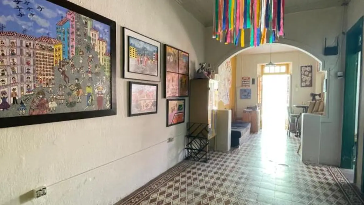 Le couloir-galerie de Hostel Canto dos Artistas, avec des tableaux et des rubans de couleur